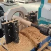 CNC wood lathe machine turning hardwood in workshop