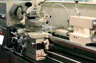 Manual engine lathe machining metal shaft in workshop