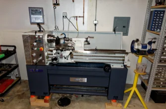 A benchtop metal lathe machining a steel part in a home workshop garage